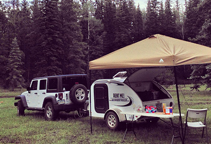 teardrop trailer and jeep in forest